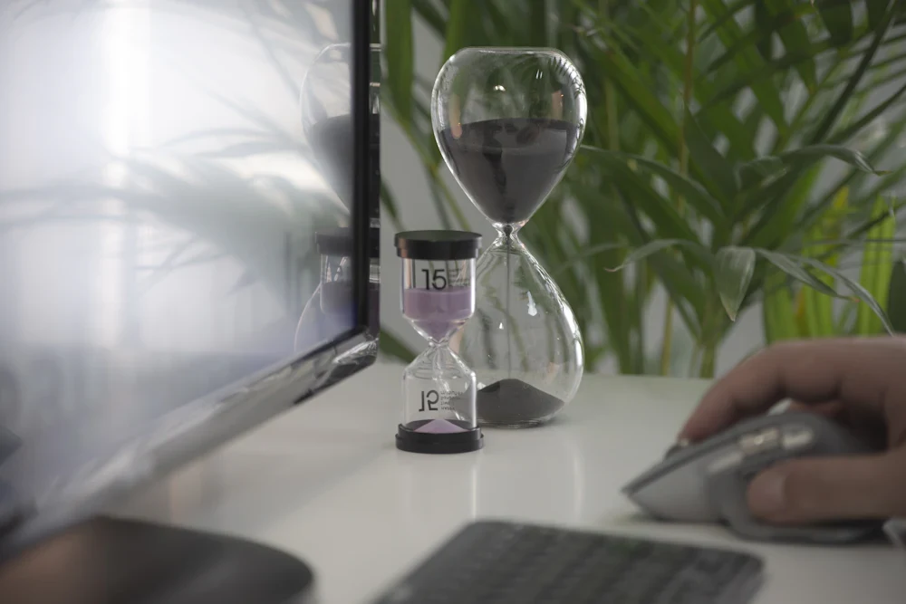 Two hourglasses beside a computer monitor