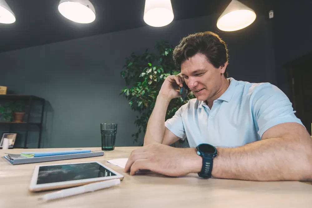 A person making a phone call at a desk